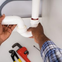 Close-up,Of,Plumber,Fitting,Sink,Pipe,In,Kitchen,At,Home