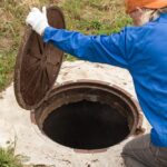 A,Working,Plumber,Opens,A,Sewer,Hatch.,Maintenance,Of,Septic